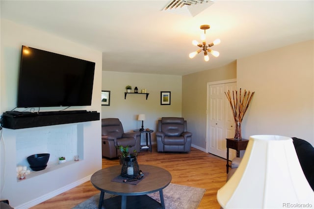 3825 S Monaco Pkwy Unit 111, Denver, CO 80237 - living room featuring a chandelier, wood finished floors, and baseboards