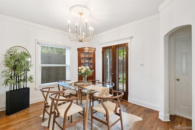 dining area with french doors, crown molding, a chandelier, and wood-type flooring