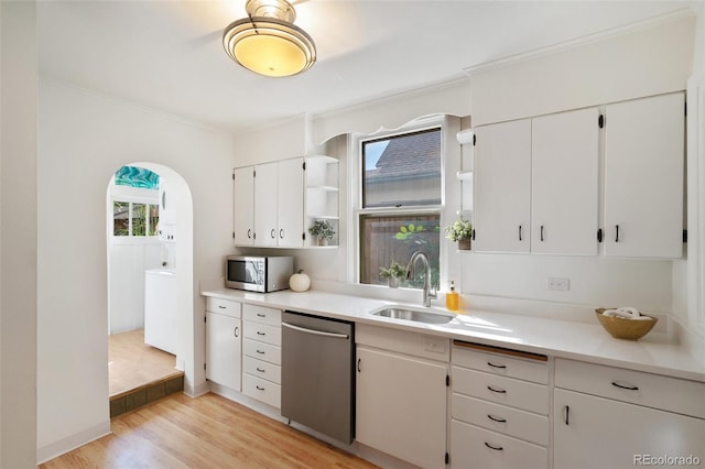 kitchen with stainless steel appliances, light hardwood / wood-style flooring, sink, white cabinets, and crown molding