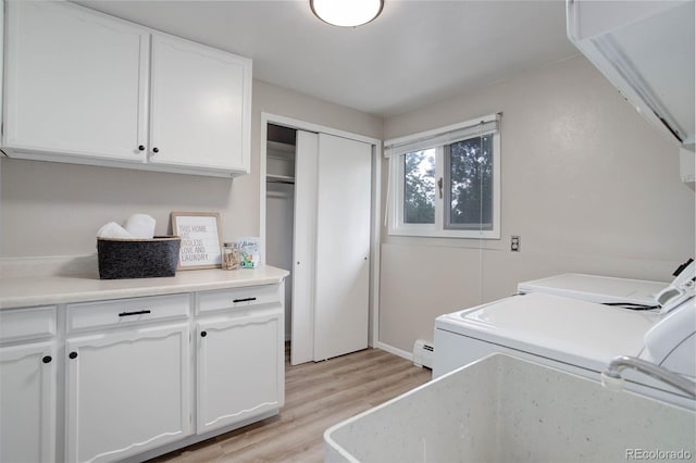 14650 Tejon St, Broomfield, CO 80023 - laundry area with cabinet space, washer and clothes dryer, light wood-style floors, and a baseboard heating unit