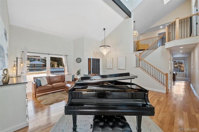 interior space featuring a notable chandelier, high vaulted ceiling, and light hardwood / wood-style flooring