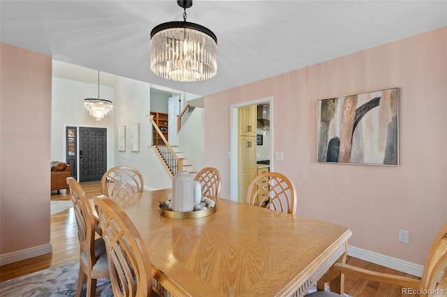 dining area with a notable chandelier and light hardwood / wood-style flooring