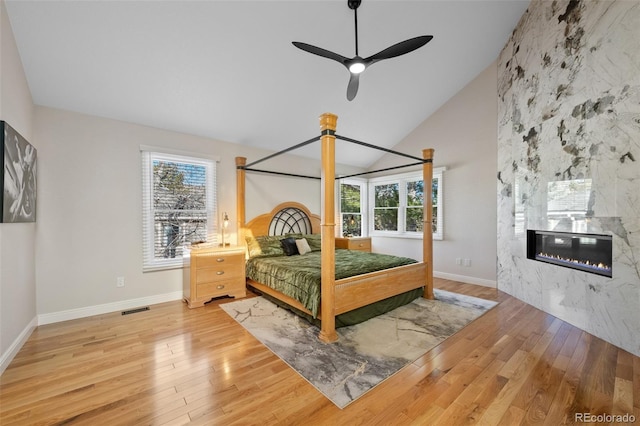 bedroom with ceiling fan, hardwood / wood-style floors, and vaulted ceiling