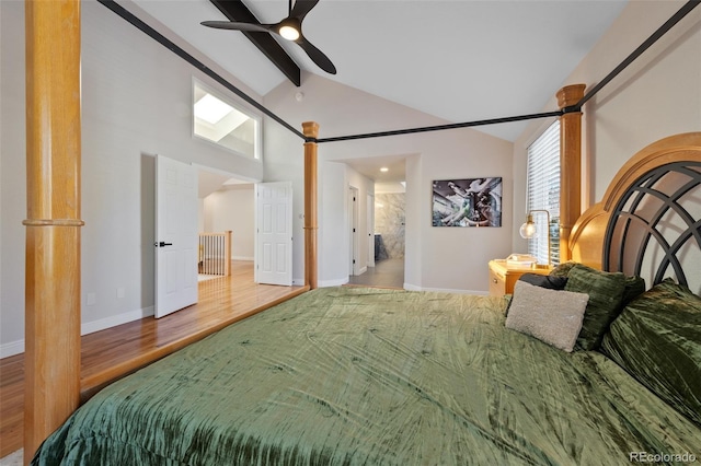 bedroom featuring vaulted ceiling with beams, ceiling fan, hardwood / wood-style floors, and ensuite bath