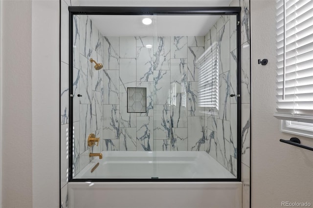 bathroom featuring combined bath / shower with glass door