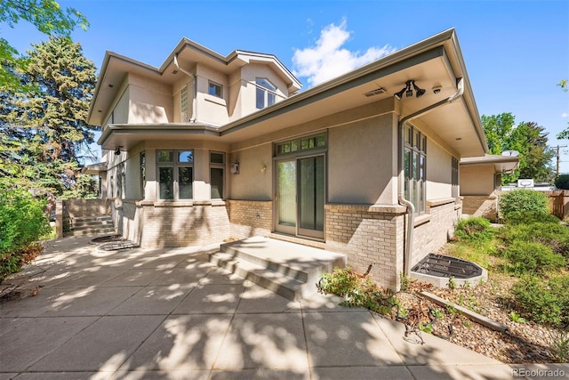 4800 E Cedar Ave, Denver, CO 80246 - view of front of home with brick siding, stucco siding, and a patio area