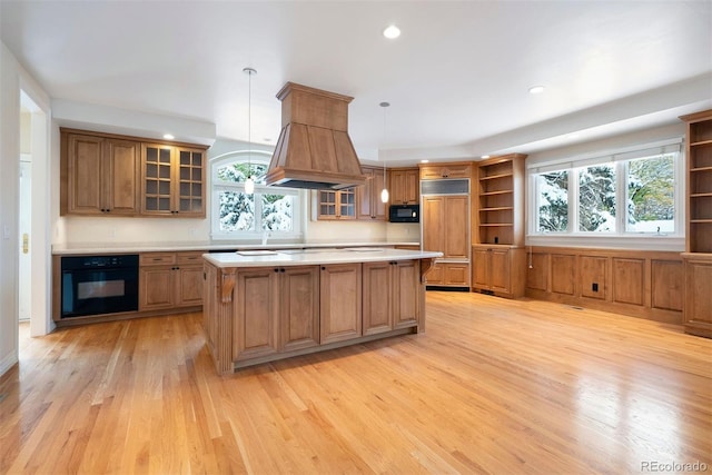 4800 E Cedar Ave, Denver, CO 80246 - kitchen featuring open shelves, black appliances, custom exhaust hood, light countertops, and light wood-style floors