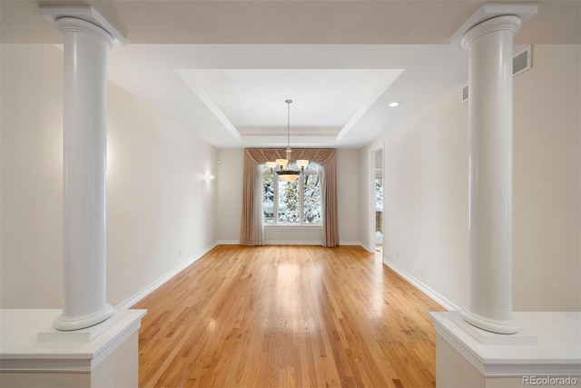 4800 E Cedar Ave, Denver, CO 80246 - unfurnished dining area with decorative columns, a tray ceiling, light wood-style flooring, baseboards, and recessed lighting