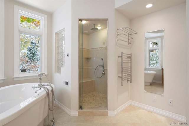 4800 E Cedar Ave, Denver, CO 80246 - bathroom featuring a shower stall, healthy amount of natural light, a soaking tub, and baseboards