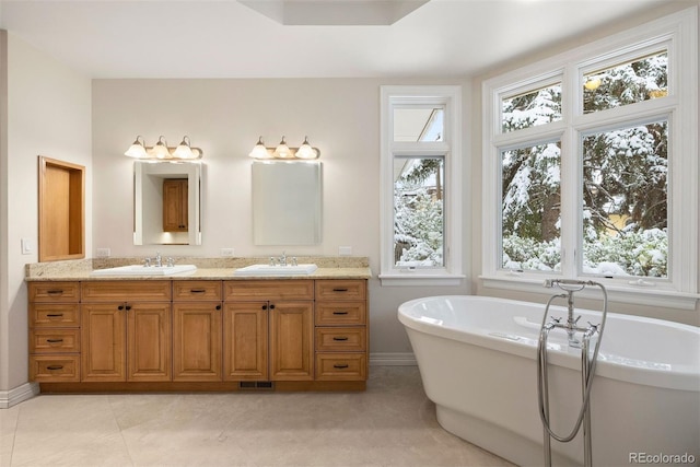 4800 E Cedar Ave, Denver, CO 80246 - full bath with a freestanding bath, double vanity, tile patterned floors, and baseboards
