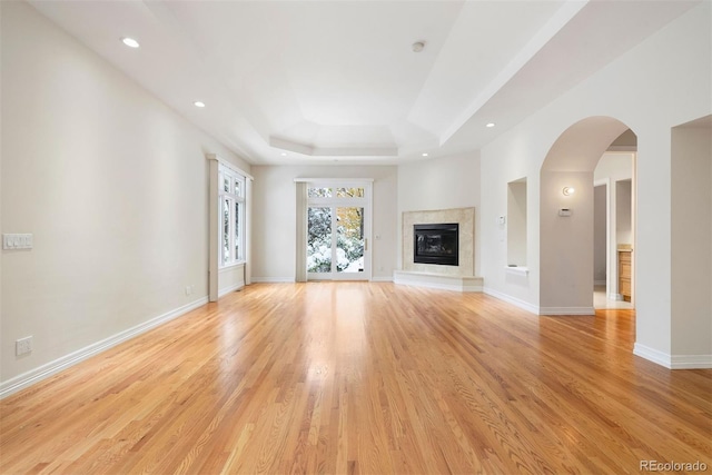 4800 E Cedar Ave, Denver, CO 80246 - unfurnished living room with recessed lighting, light wood-type flooring, baseboards, a high end fireplace, and a tray ceiling