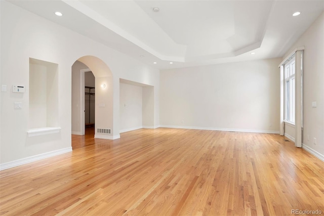 4800 E Cedar Ave, Denver, CO 80246 - empty room with light wood finished floors, arched walkways, a raised ceiling, recessed lighting, and baseboards