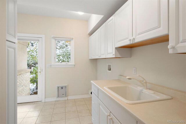 4800 E Cedar Ave, Denver, CO 80246 - laundry area featuring cabinet space, hookup for a washing machine, light tile patterned floors, and baseboards