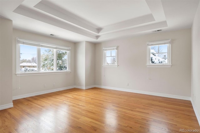 4800 E Cedar Ave, Denver, CO 80246 - spare room featuring a tray ceiling, light wood-style flooring, and baseboards