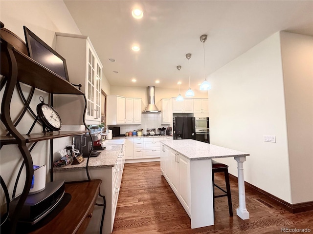185 Wildrose Ct, Woodland Park, CO 80863 - kitchen featuring wall chimney exhaust hood, stainless steel appliances, a breakfast bar, white cabinetry, and recessed lighting