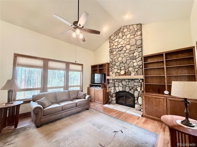 185 Wildrose Ct, Woodland Park, CO 80863 - living area featuring ceiling fan, light wood-style floors, a stone fireplace, and high vaulted ceiling