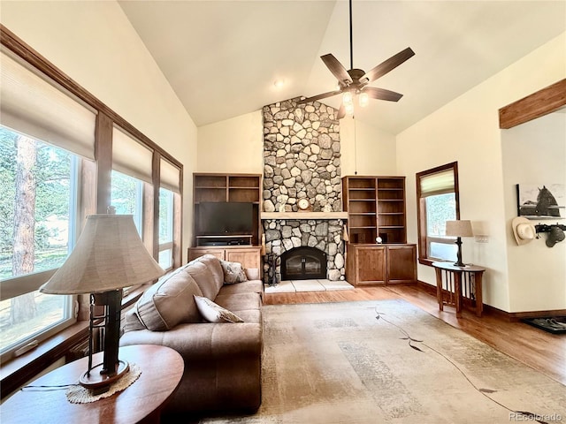185 Wildrose Ct, Woodland Park, CO 80863 - living room featuring wood finished floors, ceiling fan, high vaulted ceiling, and a stone fireplace