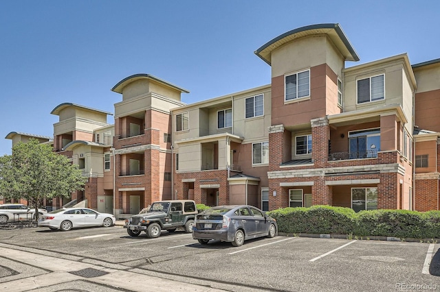 view of apartment building / complex with uncovered parking