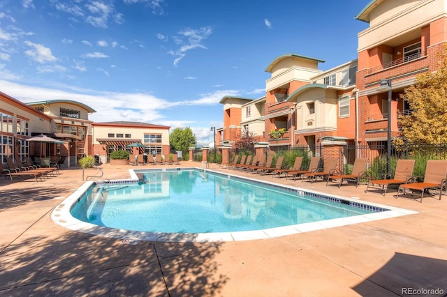 community pool featuring a patio area and fence