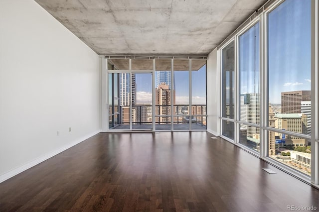 unfurnished room with a wall of windows and dark wood-type flooring