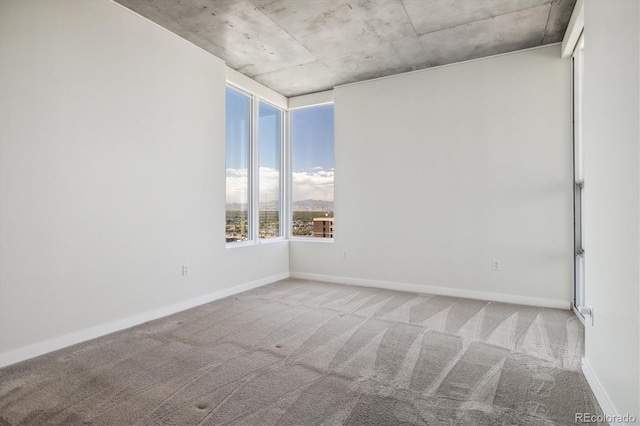 empty room with baseboards and carpet flooring