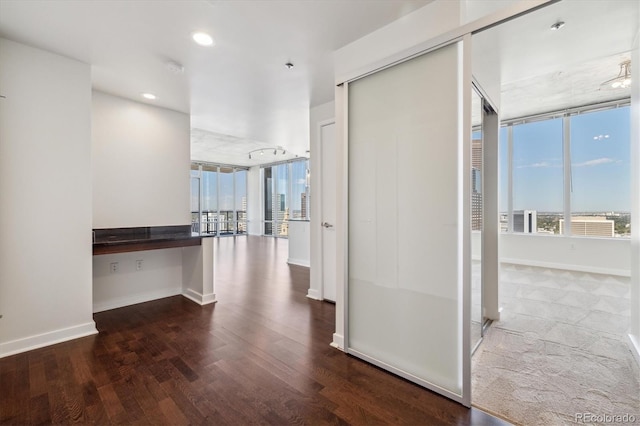 hallway featuring recessed lighting, baseboards, and wood finished floors