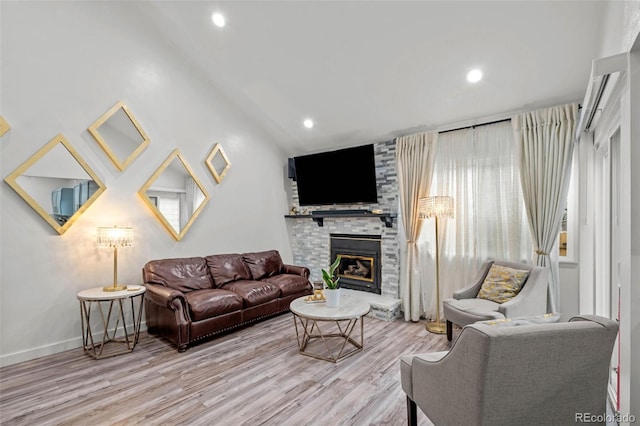 living room featuring recessed lighting, baseboards, a stone fireplace, and wood finished floors