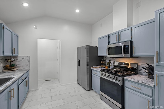 kitchen featuring light stone counters, stainless steel appliances, lofted ceiling, and marble finish floor