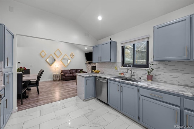 kitchen featuring stainless steel dishwasher, marble finish floor, lofted ceiling, open floor plan, and a sink