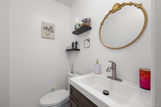 half bath featuring vanity and toilet