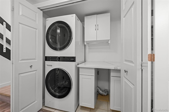 1061 S Yampa St Unit C, Aurora, CO 80017 - clothes washing area featuring light tile patterned floors, stacked washer / drying machine, and cabinet space