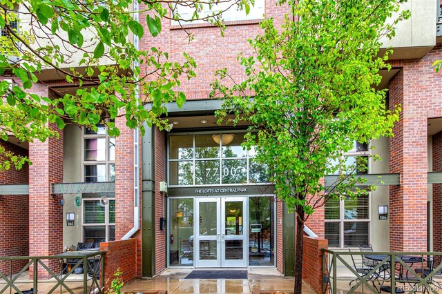 entrance to property featuring french doors and brick siding