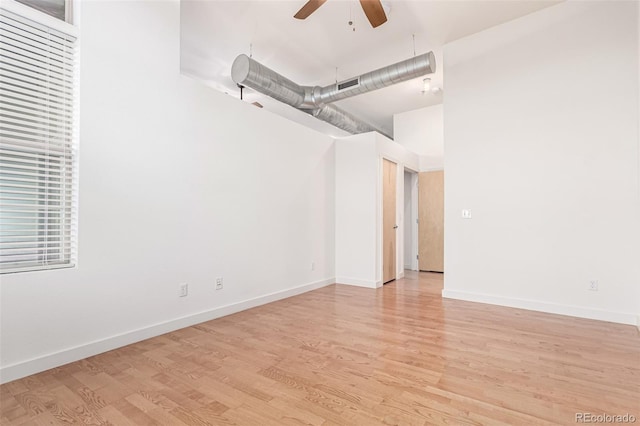 7700 E 29th Ave Unit 405, Denver, CO 80238 - spare room featuring ceiling fan, light wood finished floors, baseboards, and a towering ceiling