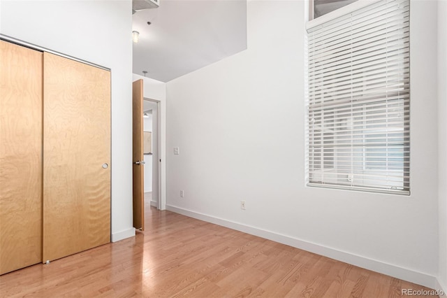 7700 E 29th Ave Unit 405, Denver, CO 80238 - unfurnished bedroom featuring light wood-style floors, baseboards, and a closet