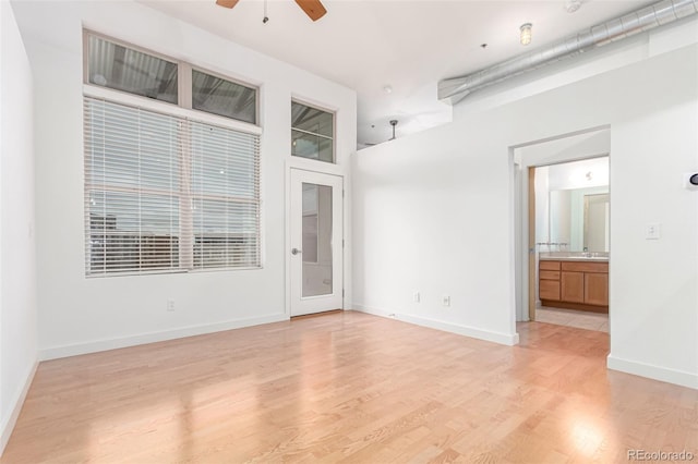 7700 E 29th Ave Unit 405, Denver, CO 80238 - empty room with ceiling fan, light wood-style floors, and baseboards