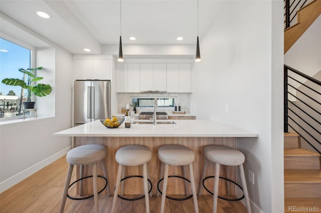 2330 Eliot St Unit 7, Denver, CO 80211 - kitchen with light wood-style flooring, high end refrigerator, white cabinetry, decorative backsplash, and modern cabinets