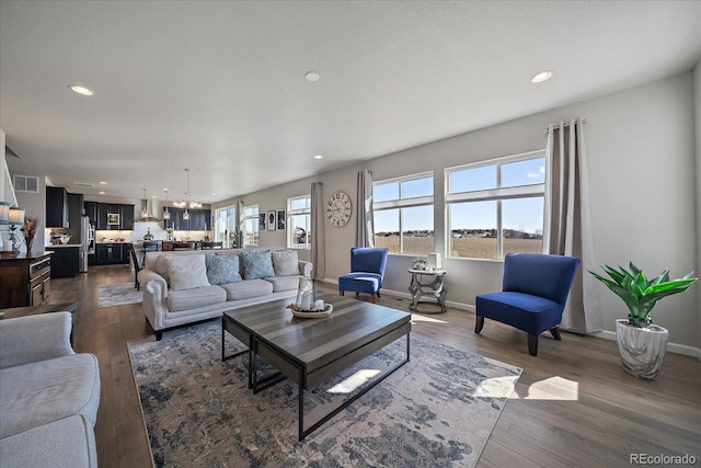 living room with recessed lighting, baseboards, and dark wood-style flooring