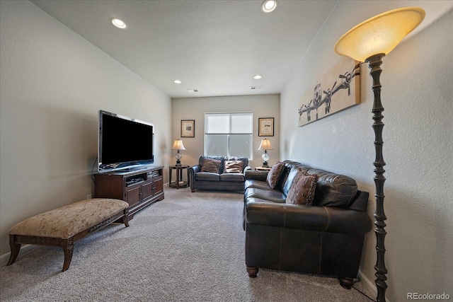 carpeted living room with recessed lighting and a textured wall