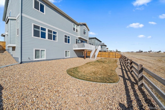 back of property with a deck, stairway, and a fenced backyard