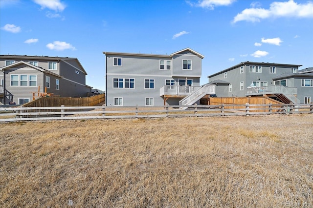 back of property featuring stairway and fence