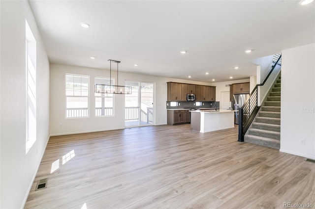 4451 Soapberry Pl, Castle Rock, CO 80108 - unfurnished living room featuring a chandelier, recessed lighting, stairway, and light wood finished floors