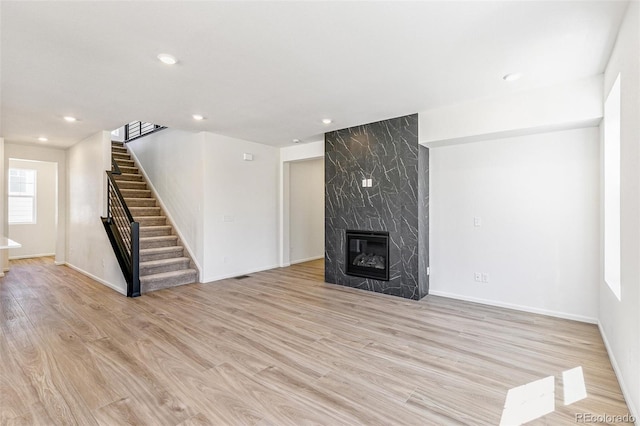 4451 Soapberry Pl, Castle Rock, CO 80108 - unfurnished living room featuring stairway, light wood finished floors, a premium fireplace, and recessed lighting