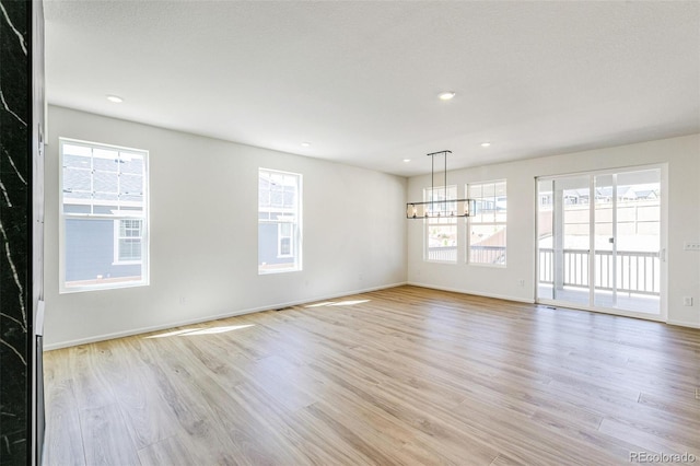 4451 Soapberry Pl, Castle Rock, CO 80108 - spare room featuring light wood-style flooring, a chandelier, healthy amount of natural light, and recessed lighting