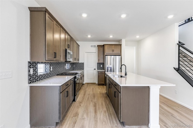 4451 Soapberry Pl, Castle Rock, CO 80108 - kitchen with appliances with stainless steel finishes, light wood-type flooring, decorative backsplash, light countertops, and recessed lighting