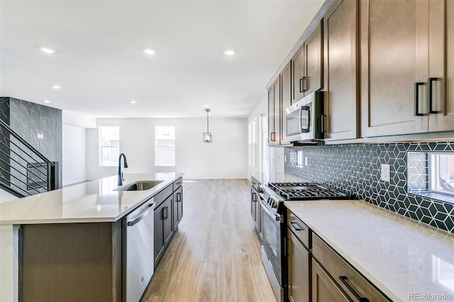4451 Soapberry Pl, Castle Rock, CO 80108 - kitchen with stainless steel appliances, light wood-style flooring, recessed lighting, decorative backsplash, and an island with sink