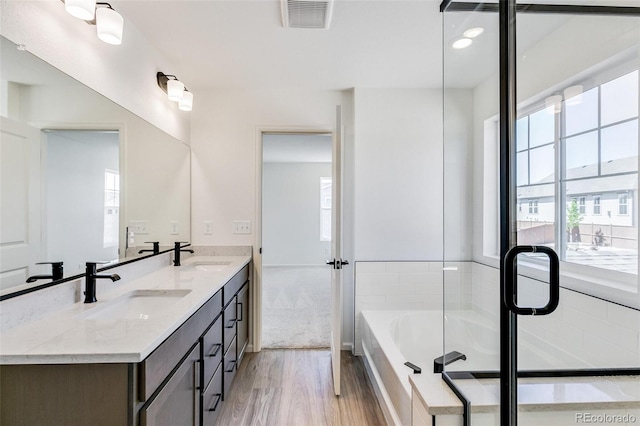4451 Soapberry Pl, Castle Rock, CO 80108 - bathroom with double vanity, wood finished floors, and a bath