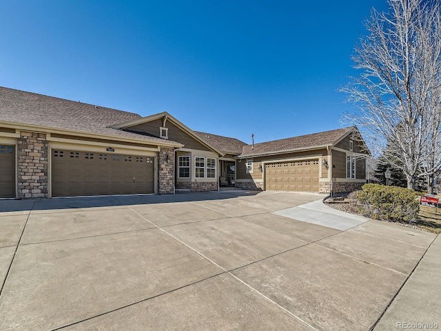 single story home with an attached garage, stone siding, concrete driveway, and roof with shingles