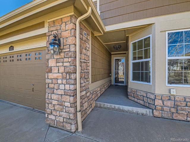 doorway to property with stone siding and an attached garage