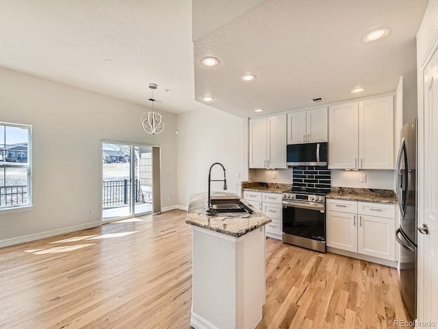 kitchen with appliances with stainless steel finishes, white cabinets, and a sink