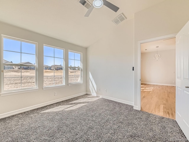 unfurnished room with carpet floors, a ceiling fan, visible vents, and baseboards